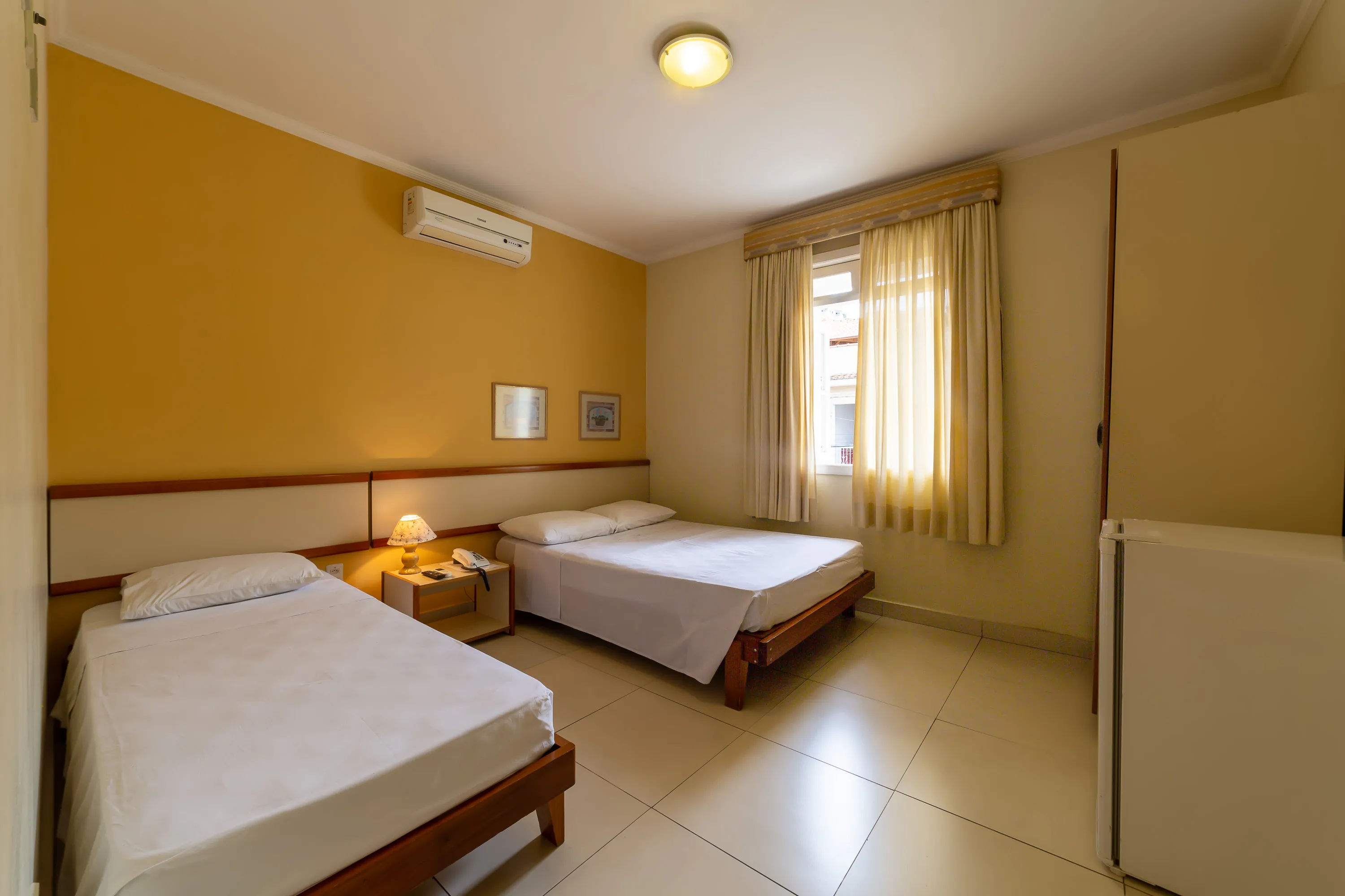 foto de quarto amplo com ar condicionado, com ar condicionado e bastante luz natural entrando pela janela grande
